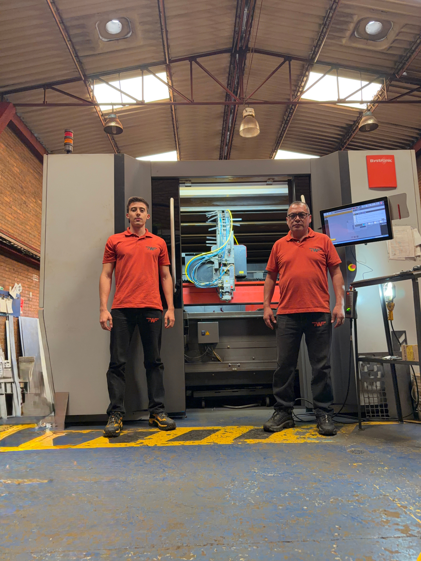 Equipo TWF frente a máquina de corte láser Bystronic en planta